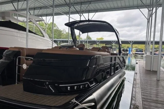 The Image of 2025 Harris Grand Mariner 230 pontoon boat docked under a covered marina. - 0