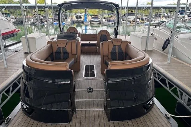 Slide: The Image of 2025 Harris Grand Mariner 230 pontoon boat with luxurious seating at a marina. - 2