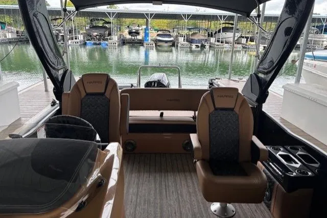 Slide: The Image of 2025 Harris Grand Mariner 230 interior with luxurious seating at a marina. - 7