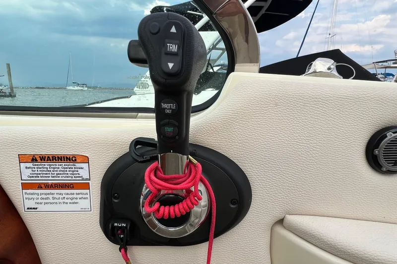 Slide: The Image of Throttle control of 2021 Chris-Craft Launch 25 GT boat with warning labels and red cord. - 18