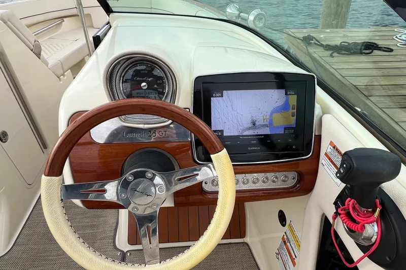 Slide: The Image of 2021 Chris-Craft Launch 25 GT dashboard with steering wheel and Garmin navigation display. - 19