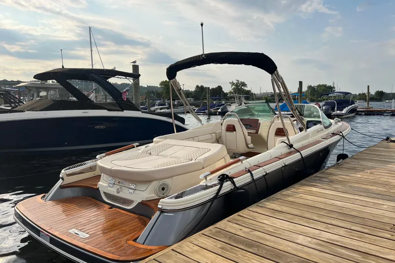 Slide: The Image of 2021 Chris-Craft Launch 25 GT boat docked, featuring elegant design and luxurious seating. - 2