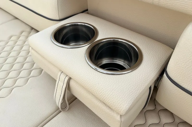 Slide: The Image of 2021 Chris-Craft Launch 25 GT boat interior with dual cup holders on beige leather seats. - 8