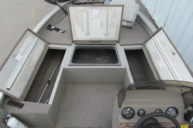 Slide: The Image of 1998 Tracker boat interior with open storage compartments and control panel. - 6