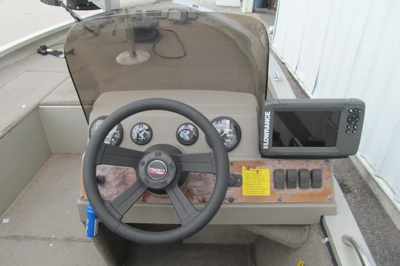 Slide: The Image of 1998 Tracker boat dashboard with steering wheel, gauges, and Lowrance fish finder. - 7