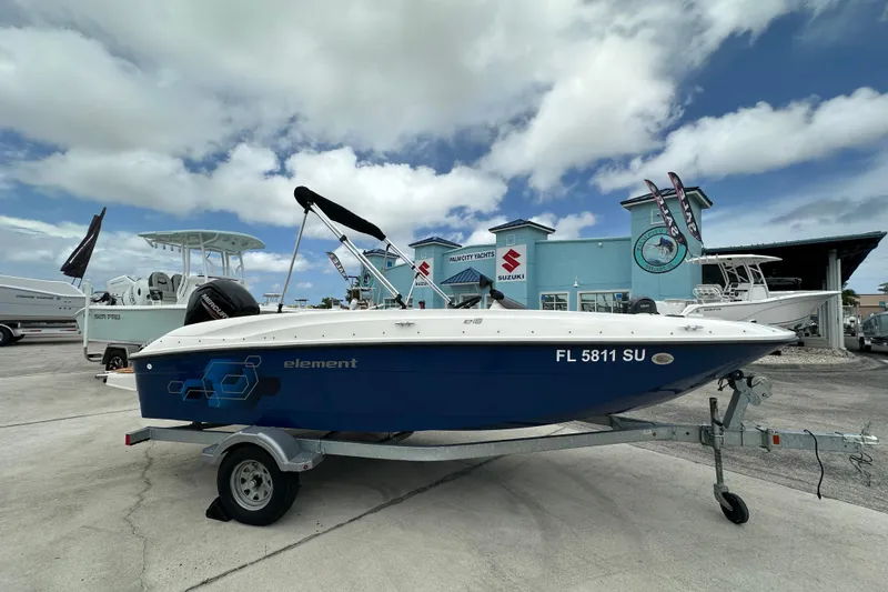 The Image of 2021 Bayliner Element E18 boat on trailer at dealership under cloudy sky. - 1