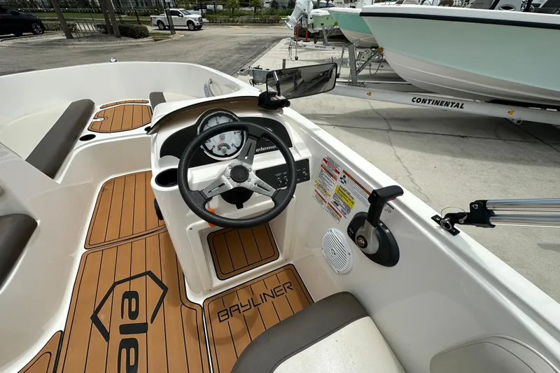 Slide: The Image of 2021 Bayliner Element E18 boat interior with steering wheel and dashboard controls. - 4