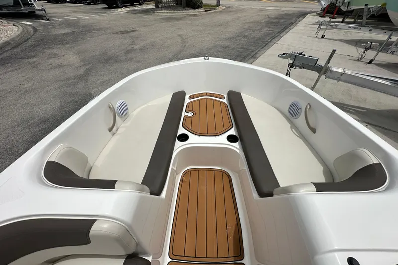 Slide: The Image of 2021 Bayliner Element E18 boat interior with cushioned seating and wood accents. - 5