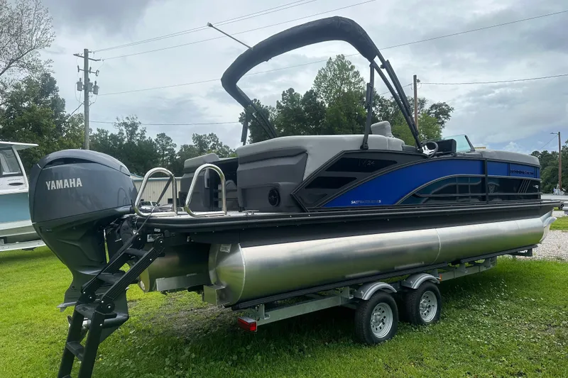 Slide: The Image of 2025 Bennington 24M pontoon boat with Yamaha engine on trailer, parked on grass. - 3