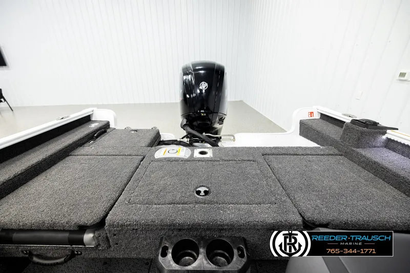 Slide: The Image of 2026 Lund 1775 Adventure SS boat interior with motor, featuring carpeted deck and storage compartments. - 19