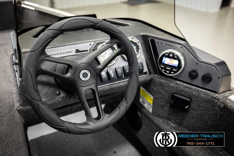 Slide: The Image of 2026 Lund 1775 Adventure SS boat dashboard with steering wheel and control panel. - 27