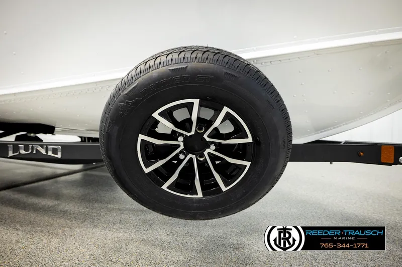 Slide: The Image of 2026 Lund 1775 Adventure SS boat trailer wheel with sleek black and silver rim design. - 46