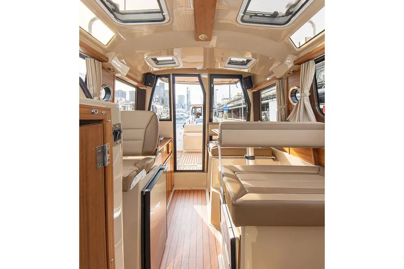 Slide: The Image of Manufacturer Provided Image: Interior of 2025 Ranger Tugs R-23 boat, featuring elegant seating and wood finishes. - 12