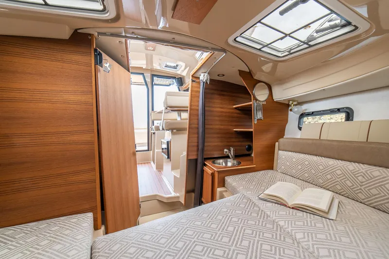Slide: The Image of Manufacturer Provided Image: Interior of 2025 Ranger Tugs R-23 boat, featuring cozy cabin with bed and kitchenette. - 18