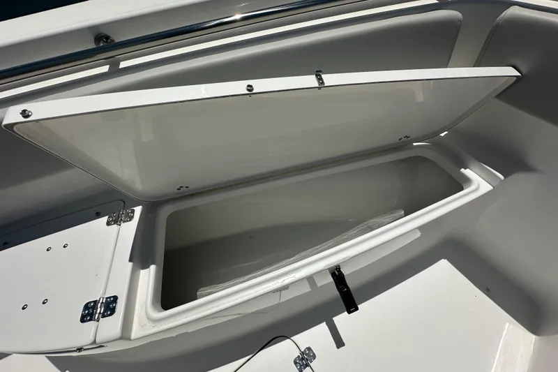 Slide: The Image of 2026 Sea Pro 222 Center Console boat storage compartment open, showcasing interior space. - 6