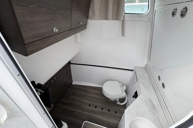 Slide: The Image of 2026 Sportsman Heritage 321 Center Console boat interior with compact bathroom amenities. - 14