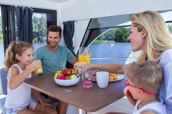 Slide: The Image of Family enjoying breakfast on a 2024 Beneteau Antares 9 boat. - 10