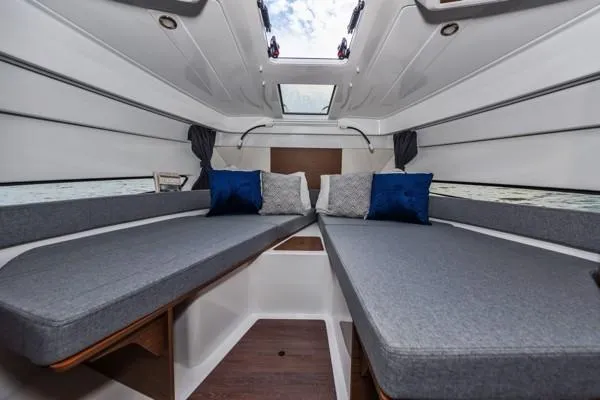 Slide: The Image of 2024 Beneteau Antares 9 cabin interior with twin beds and skylight. - 13