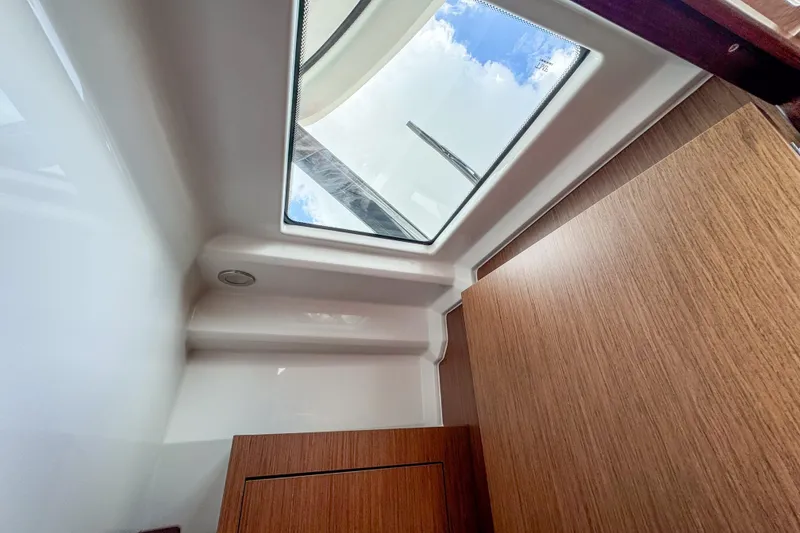 Slide: The Image of Interior view of 2026 Beneteau Antares 9 with skylight and wooden paneling. - 25