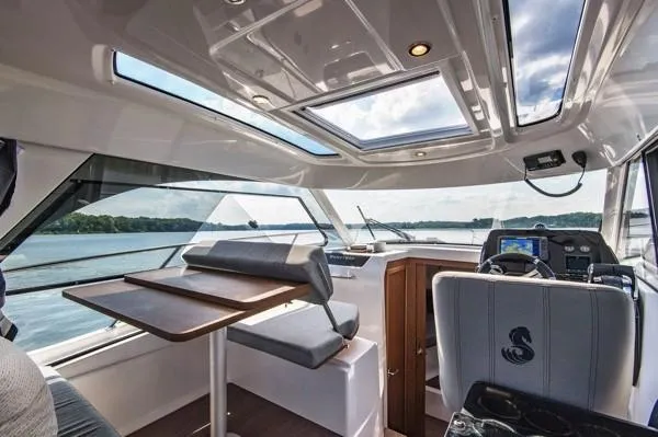 Slide: The Image of Interior of 2024 Beneteau Antares 9 boat with panoramic windows and modern seating. - 6