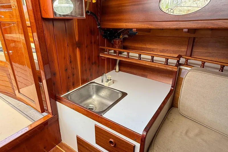 Slide: The Image of Wooden interior of 2012 Herreshoff Custom Hyland Design "Rozinante" with sink and seating area. - 15