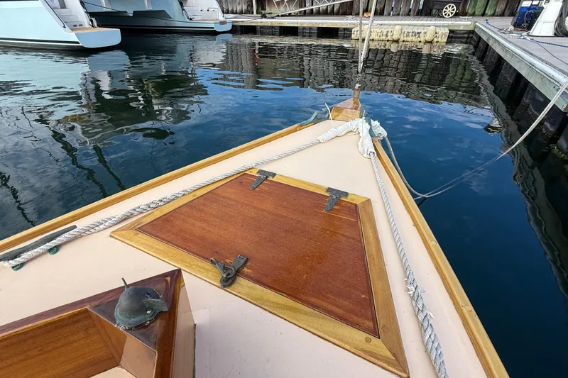 Slide: The Image of Herreshoff Custom Hyland Design "Rozinante" 2012 sailboat docked, showcasing wooden deck details. - 26