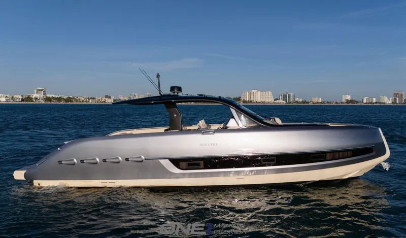Slide: The Image of 2024 Invictus TT460 luxury yacht on calm waters with city skyline in the background. - 0