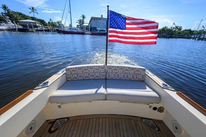 Slide: The Image of 2014 Hinckley Talaria 29C boat with American flag on calm water. - 10