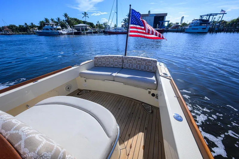 Slide: The Image of 2014 Hinckley Talaria 29C boat with American flag on calm water. - 11
