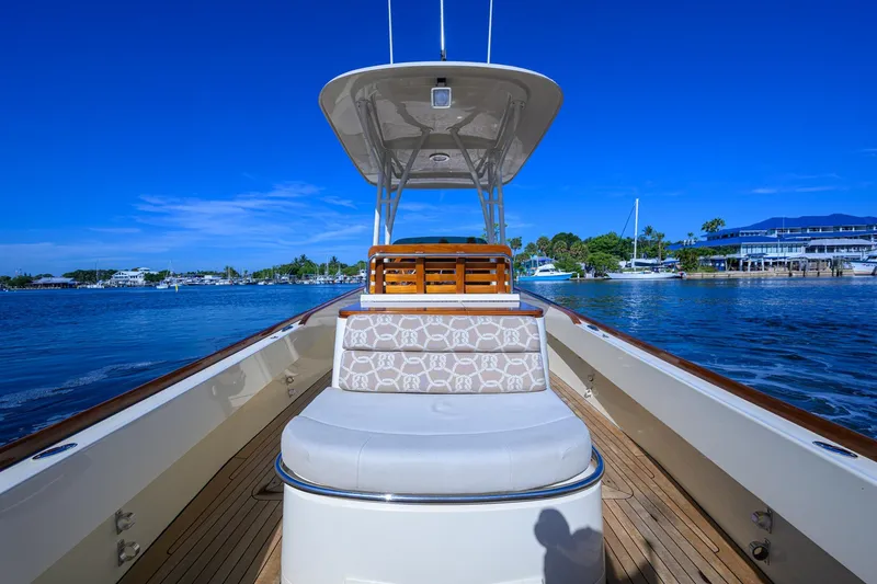 Slide: The Image of 2014 Hinckley Talaria 29C boat on water, featuring elegant seating and clear blue skies. - 12