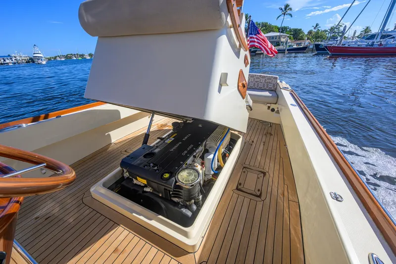 Slide: The Image of 2014 Hinckley Talaria 29C boat with open engine compartment, docked by the water. - 14