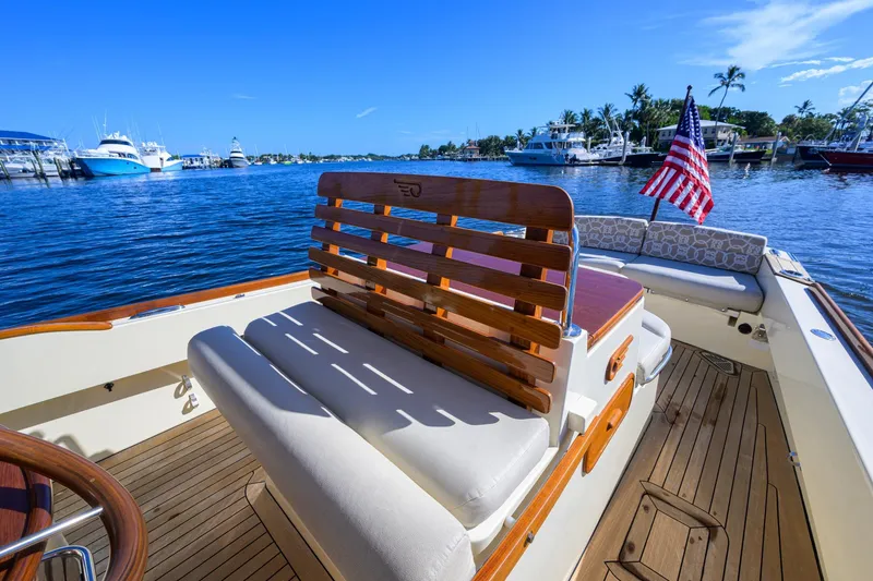 Slide: The Image of 2014 Hinckley Talaria 29C boat interior with wooden seating and American flag. - 15