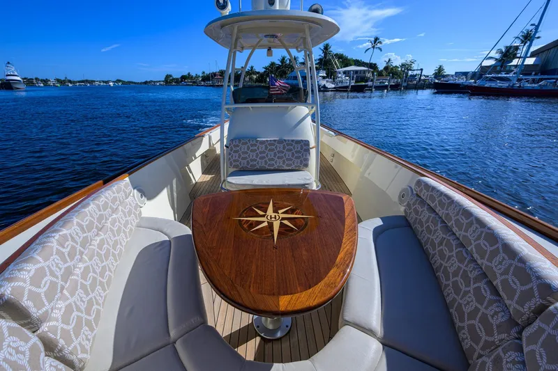 Slide: The Image of 2014 Hinckley Talaria 29C boat interior with elegant seating and wooden table on a sunny day. - 16