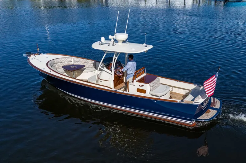 Slide: The Image of 2014 Hinckley Talaria 29C cruising on calm water with American flag. - 2