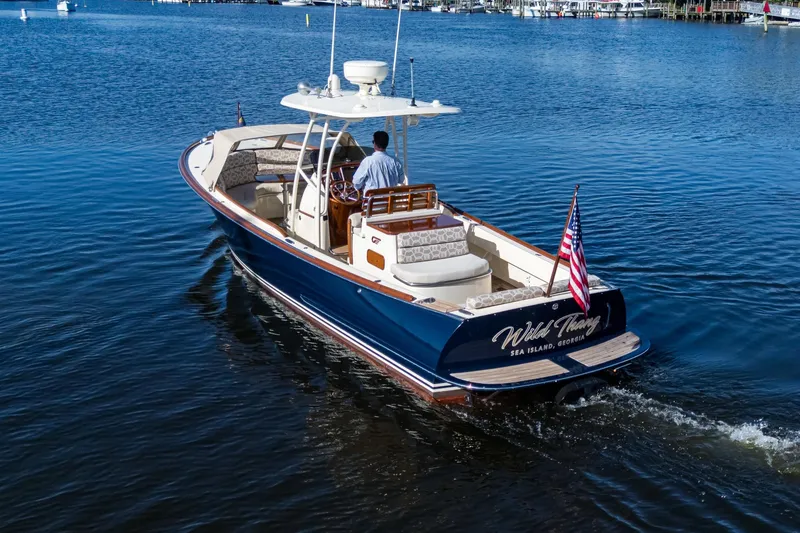 Slide: The Image of 2014 Hinckley Talaria 29C cruising on calm waters, displaying American flag. - 7