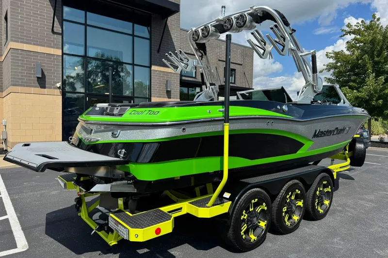 Slide: The Image of 2015 MasterCraft X30 boat with vibrant green accents on a trailer. - 3
