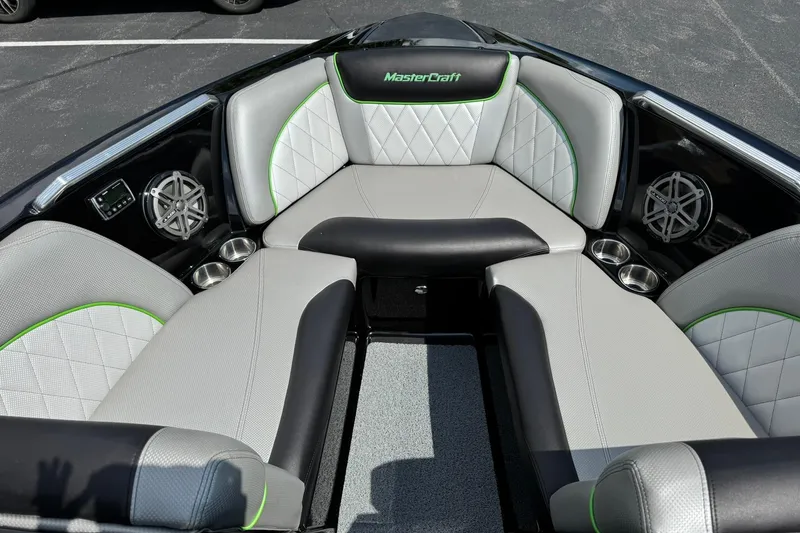 Slide: The Image of 2015 MasterCraft X30 boat interior with gray and green seating, cup holders, and speakers. - 7