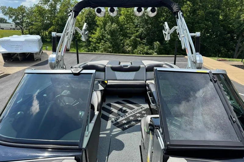 Slide: The Image of 2015 MasterCraft X30 boat interior with open windshield, tower speakers, and seating area. - 8
