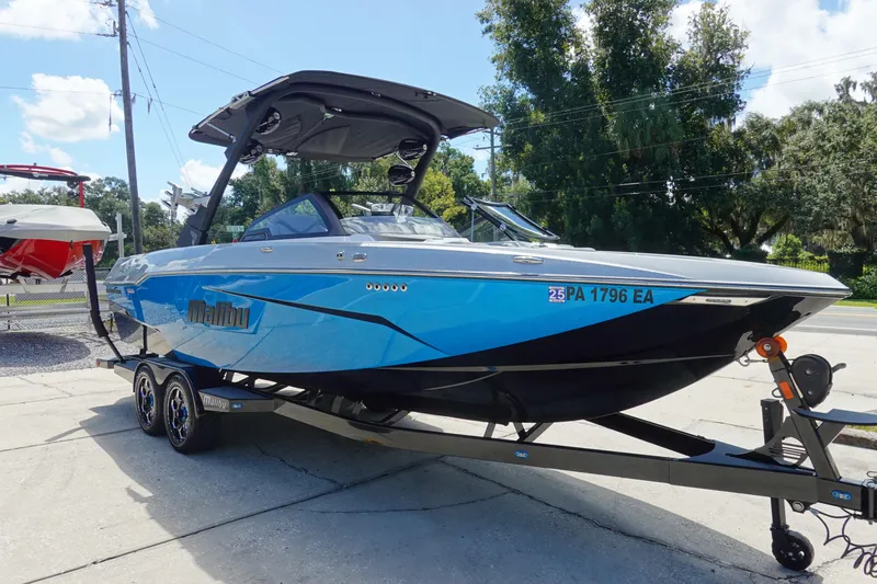 Slide: The Image of 2021 Malibu Wakesetter 25 LSV boat on trailer, blue exterior, parked outdoors. - 3