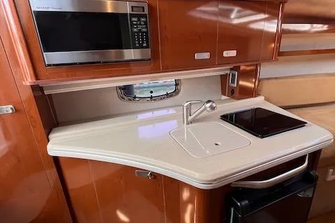 Slide: The Image of 2011 Sea Ray 280 Sundancer galley with microwave, sink, and cooktop. - 12