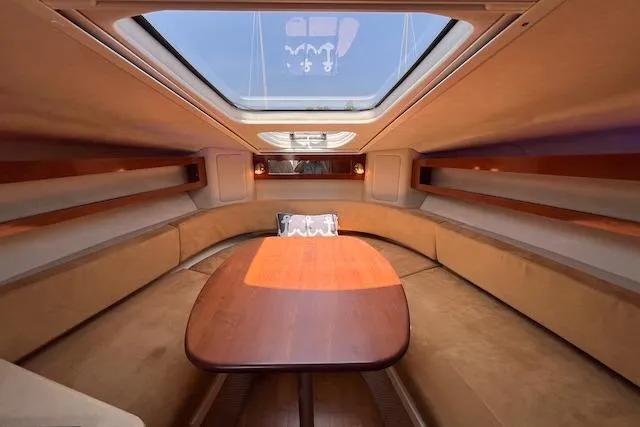 Slide: The Image of Interior of 2011 Sea Ray 280 Sundancer with skylight and wooden table. - 16