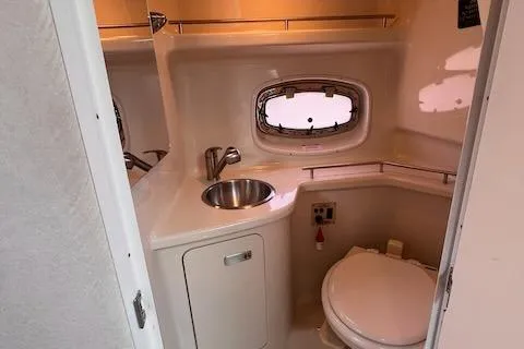 Slide: The Image of 2011 Sea Ray 280 Sundancer bathroom with sink, toilet, and porthole window. - 17