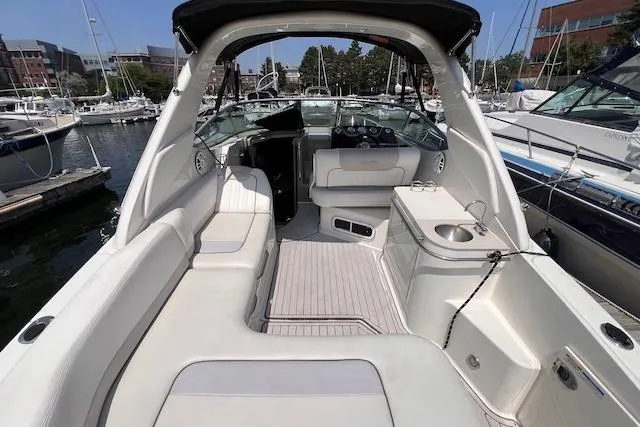 Slide: The Image of 2011 Sea Ray 280 Sundancer boat interior with seating and helm, docked at marina. - 3