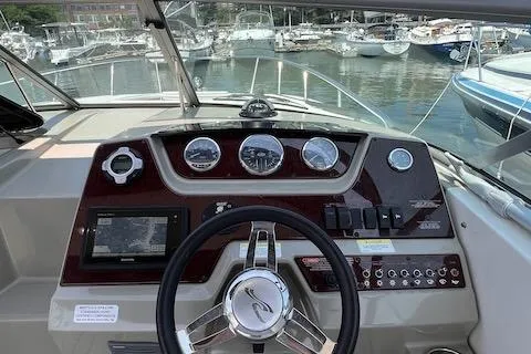 Slide: The Image of 2011 Sea Ray 280 Sundancer dashboard with steering wheel and gauges, docked at marina. - 6