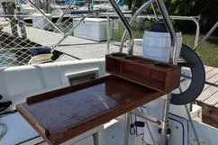 Slide: The Image of Cockpit of 1992 Hunter 33.5 sailboat with wooden table and marina background. - 3