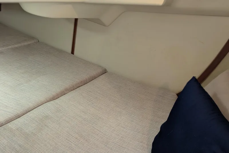 Slide: The Image of Interior cabin of 1992 Hunter 33.5 sailboat with cushioned seating and blue pillow. - 6