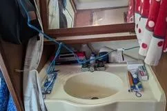 Slide: The Image of 1992 Hunter 33.5 yacht bathroom with sink, mirror, and toiletries. - 7