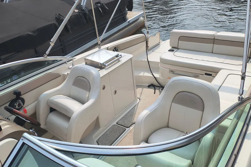 Slide: The Image of 2009 Sea Ray 280 Sundeck interior with seating and helm, docked by the water. - 4