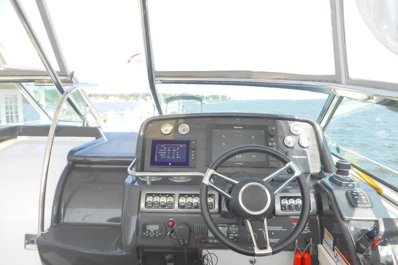 Slide: The Image of 2017 Formula 37 PC yacht helm with advanced navigation controls and scenic water view. - 17