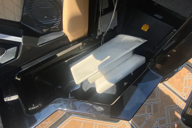 Slide: The Image of 2023 Tigé 23ZX boat interior storage compartment with white cushions and speaker. - 19